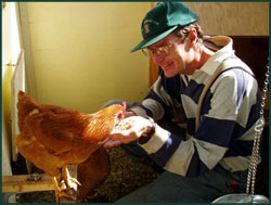 Brother Michael, feeding a hen