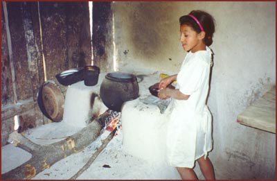 girl cooking over fireplace